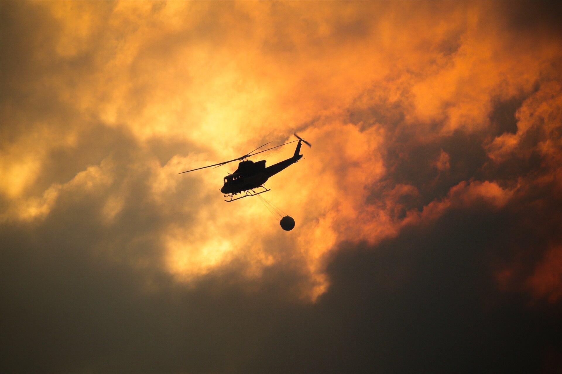 Un helicóptero recoge agua para ayudar con las labores de extinción de un incendio.(Adrián Irago / Europa Press)