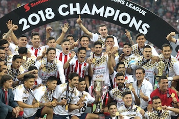 Mexico's Guadalajara players hold their trophy following victory over Canada's Toronto FC in their final second leg football match of the CONCACAF Champions League at Akron stadium in Guadalajara, Jalisco State, Mexico on April 25, 2018. / AFP PHOTO / ULISES RUIZ