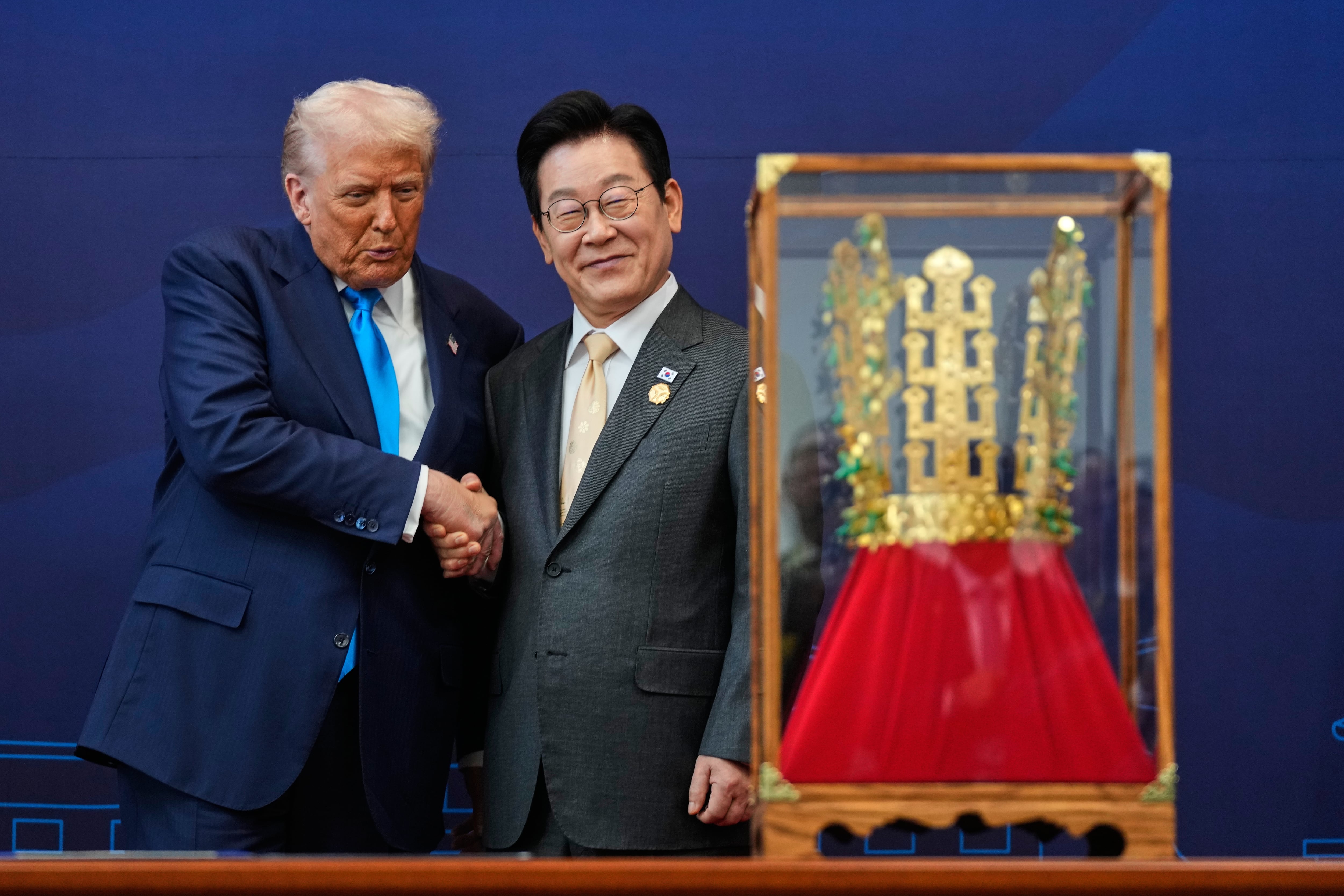 El presidente de EEUU, Donald Trump, estrecha la mano del presidente surcoreano Lee Jae Myung mientras recibe un regalo consistente en una corona de oro y una condecoración de la Gran Orden de Mugunghwa, que no se ve en la imagen, durante una ceremonia celebrada en el Museo Nacional de Gyeongju, en Corea del Sur, el miércoles 29 de octubre de 2025 (AP Foto/Mark Schiefelbein)