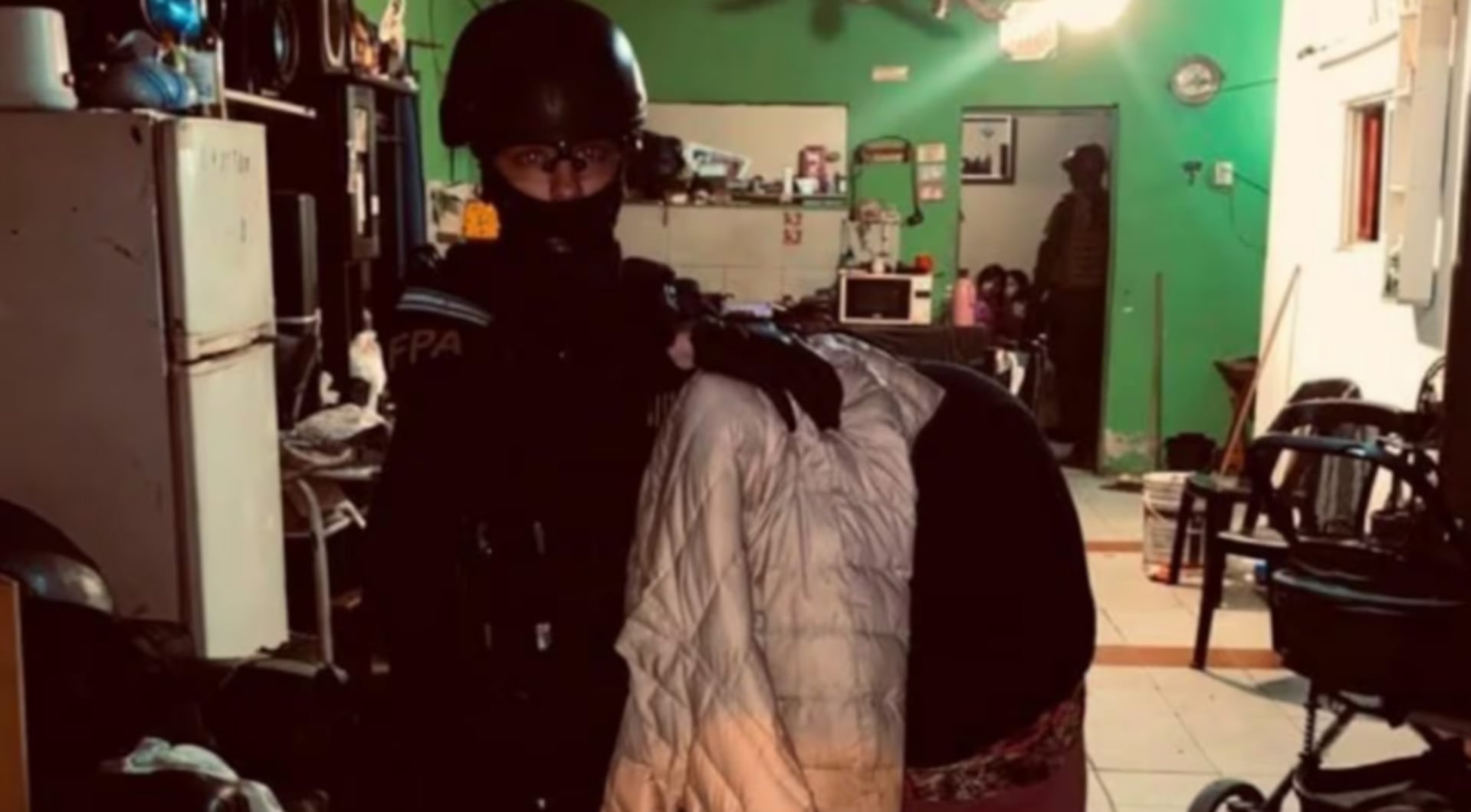 Un agente de la FPA acompaña a una mujer detenida durante un operativo por venta de drogas en una vivienda de Córdoba (El Doce.tv)