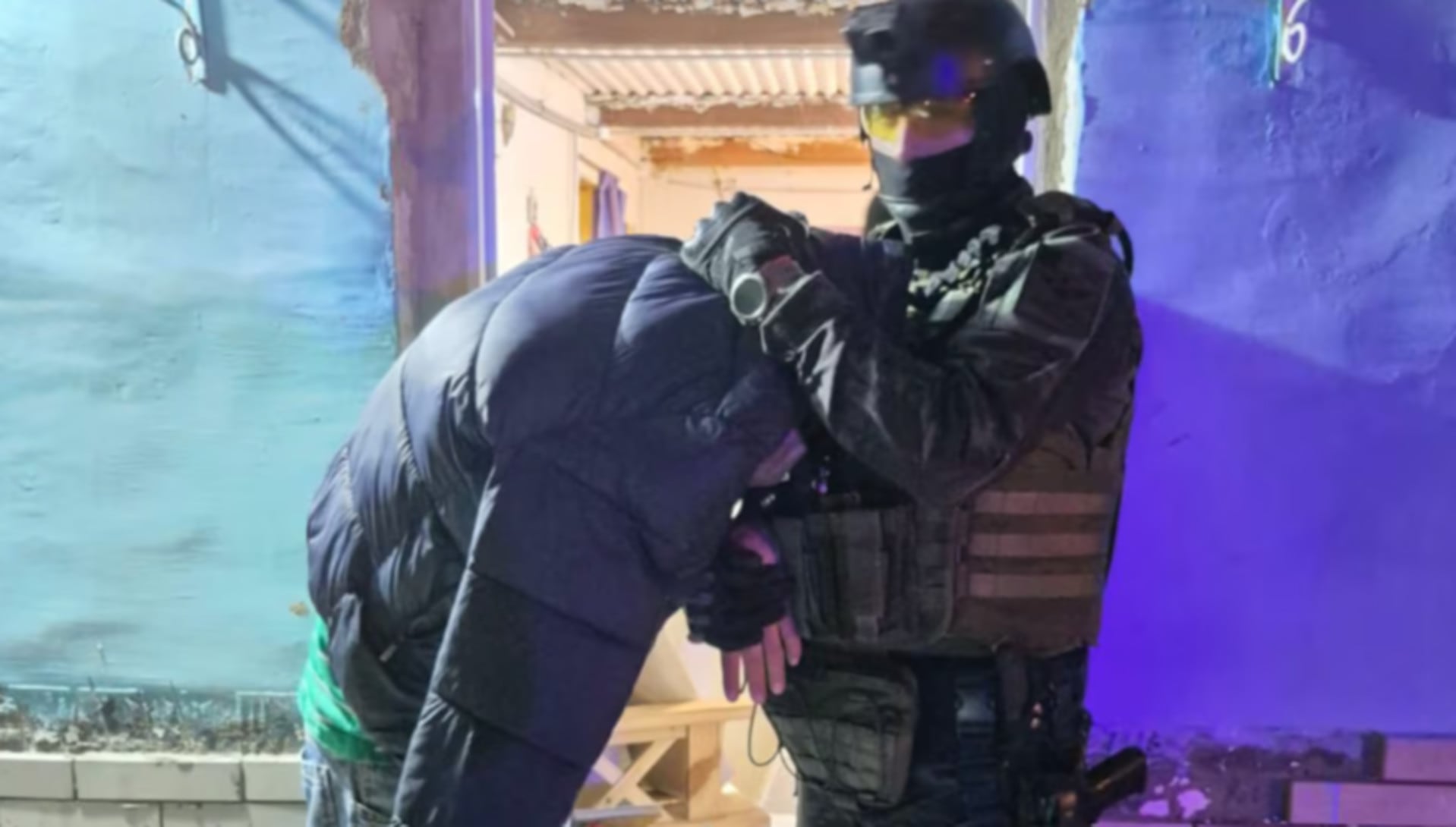 Un miembro de la Fuerza Policial Antinarcotráfico (FPA) detiene a un individuo durante un allanamiento relacionado con drogas cerca de una escuela en Corral de Bustos, Córdoba. (El Doce.tv)