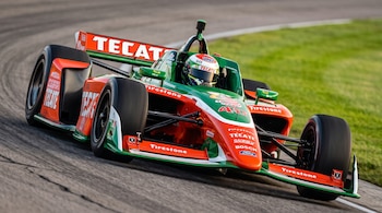 Un automóvil de carreras monoplaza verde y naranja con el número 40 y patrocinio de Tecate circula por una pista de asfalto.