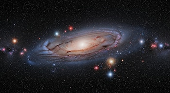Imagen de una galaxia espiral con un núcleo brillante y brazos tenues de gas y polvo, rodeada por un campo oscuro salpicado de estrellas brillantes.
