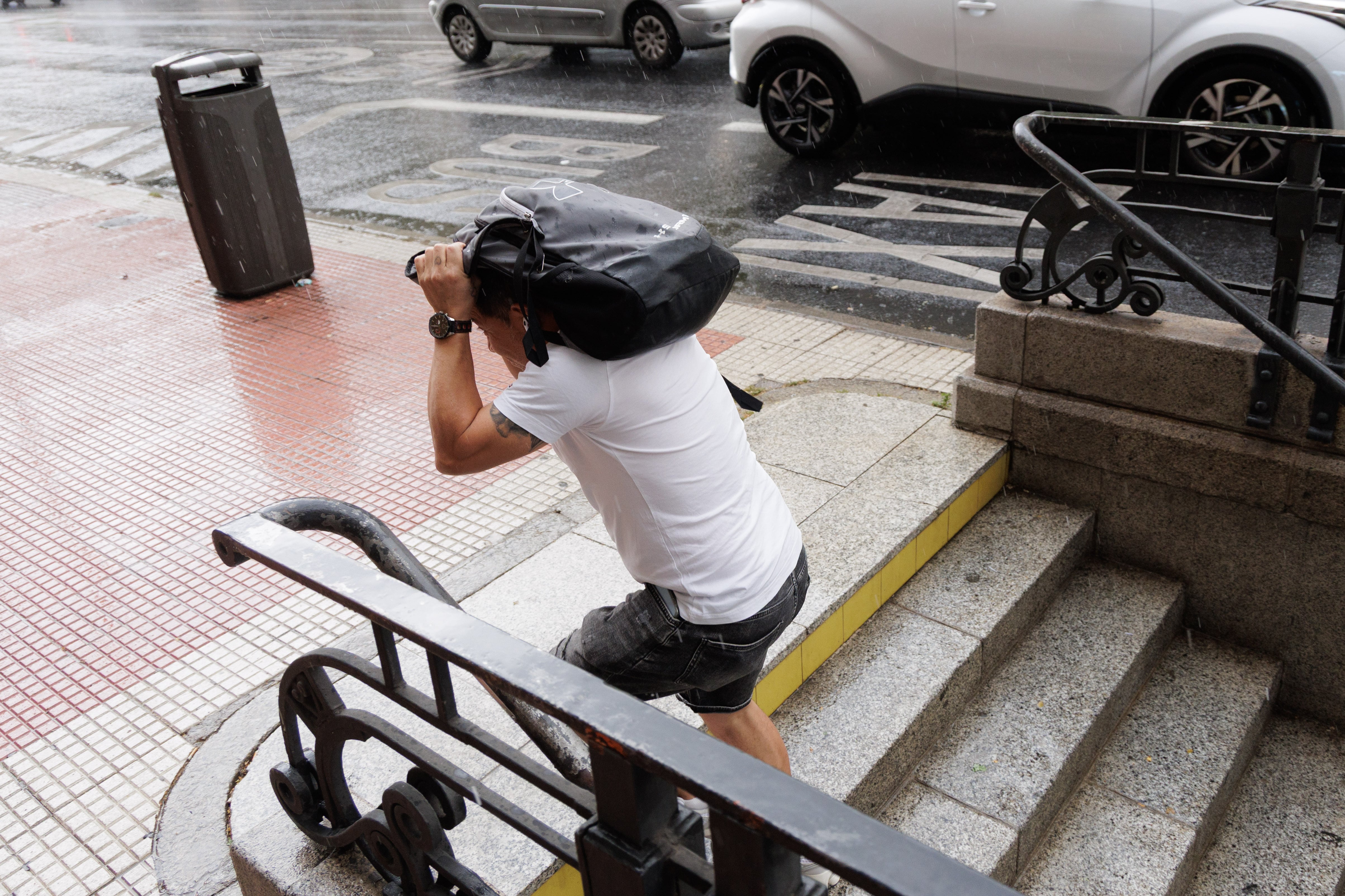 Un hombre se protege de la lluvia con una mochila, a 25 de junio de 2026, en Madrid (España). (Carlos Luján/Europa Press)