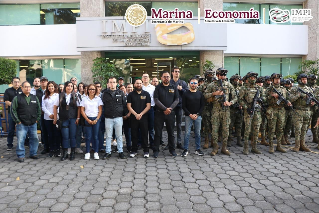 Funcionarios del Instituto Mexicano de la Propiedad Industrial y la Secretaría de Economía posan junto a elementos armados de la Secretaría de Marina frente a la sede institucional en México. (Marina )