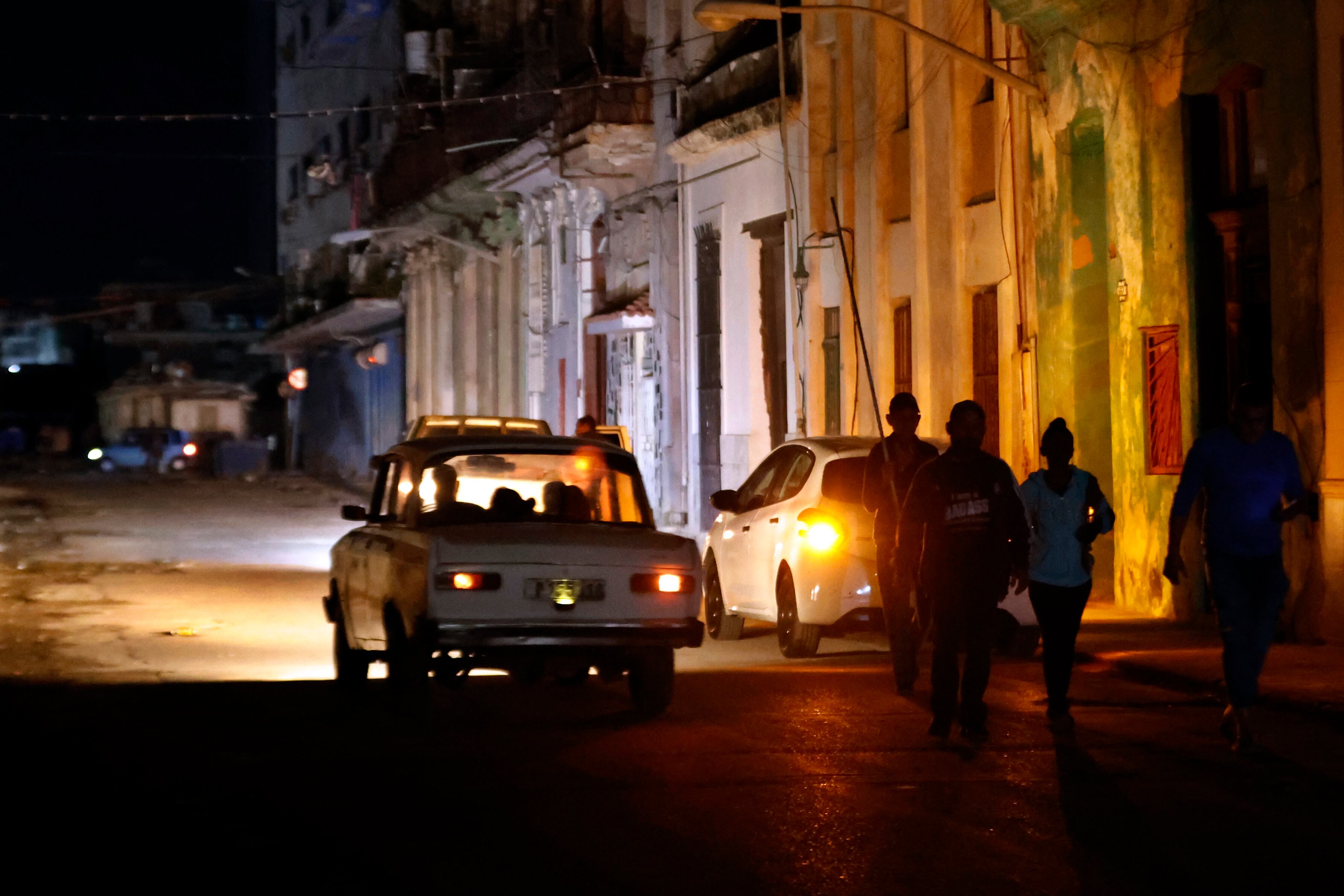 Fotografía de archivo de personas caminando por un sector sin servicio eléctrico en La Habana (EFE/Ernesto Mastrascusa/Archivo)