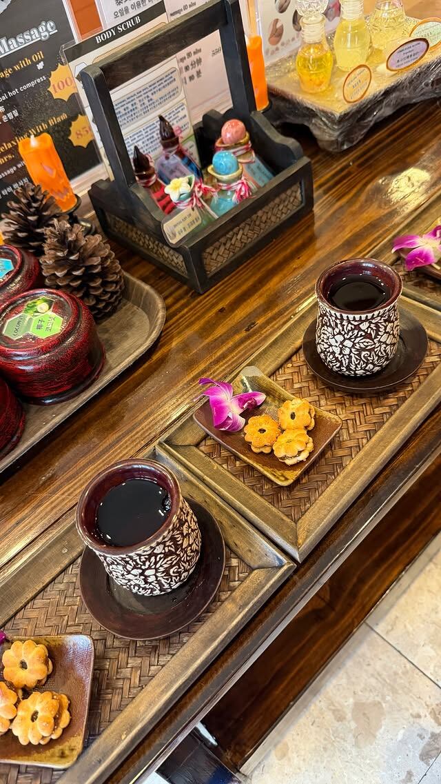 Pausa gourmet: Juli y su amiga disfrutan de infusiones y galletitas en vajilla tradicional tailandesa, saboreando lo mejor de la cultura local