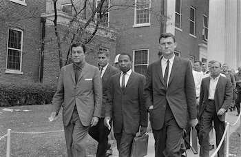 James Meredith camina hacia sus clases en la Universidad de Mississippi custodiado por agentes federales, el 1 de octubre de 1962