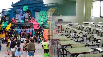 Edificio azul con mural de colores, multitud en evento exterior y farola; fusionado con aula vacía que contiene pupitres, sillas y un pizarrón verde.