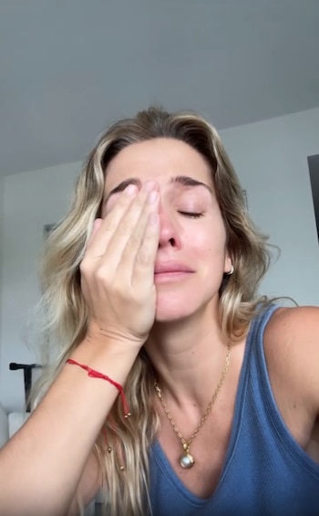 Soledad Fandiño con la mano en el rostro, los ojos cerrados y la boca contraída en un gesto de llanto
