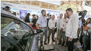 El ministro de Comercio Exterior y la Inversión Extranjera de Cuba, Oscar Pérez-Oliva Fraga, observa un automóvil de fabricación china a la venta durante la 41.ª Feria Internacional de La Habana, el 25 de noviembre de 2025. ADALBERTO ROQUE / AFP