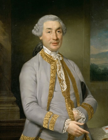 Retrato al óleo de un hombre con peluca, traje gris con adornos dorados, camisa blanca con encaje, junto a una columna y un paisaje