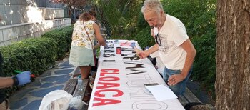 Un vecino prepara una pancarta.