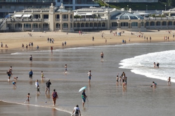 Bañistas disfrutan de un dia soleado en la playa de la Concha de San Sebastián a 8 de abril de 2026. (EFE/Juan Herrero)