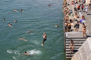 Basilea integra el río Rin a la vida diaria y mantiene una tradición de baño urbano que en verano incluye traslados al trabajo por la corriente (REUTERS/Bernadett Szabo)