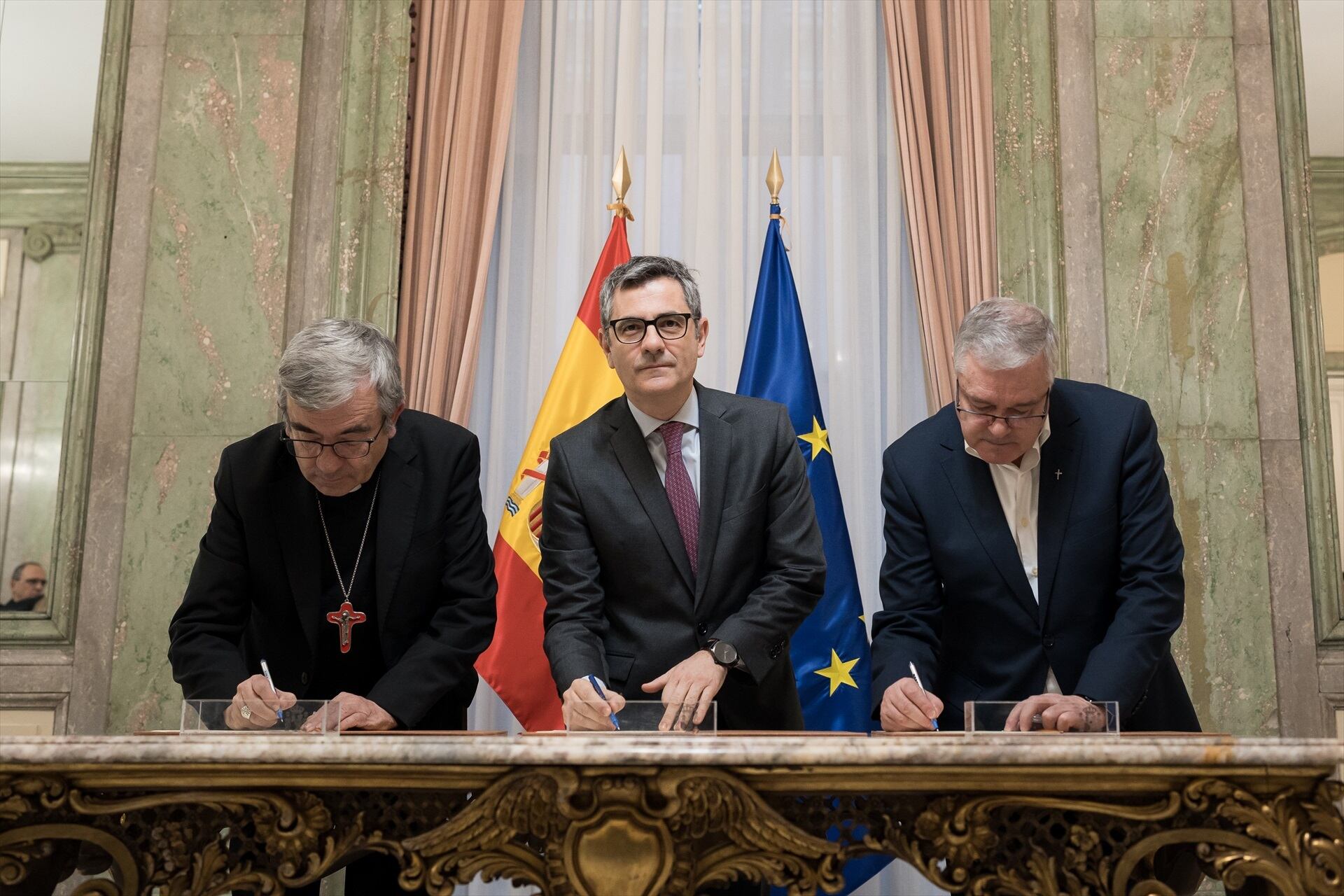 El ministro de la Presidencia, Félix Bolaños (c), el presidente de la Confederación Episcopal Española, Luis Argüello (i), y el Presidente de la Conferencia Española de Religiosos, Jesús Díaz Sariego (d). (Diego Radamés / Europa Press)