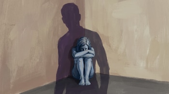 Dibujo de una mujer acurrucada en una esquina, mientras la sombra oscura de un hombre se proyecta en la pared detrás de ella.