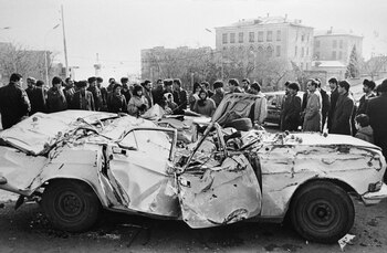 Azerbaiyanos observan un auto destruido