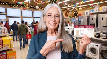 Mujer con anteojos sostiene una credencial con el logotipo de INAPAM y del Gobierno de México dentro de una tienda con electrodomésticos.