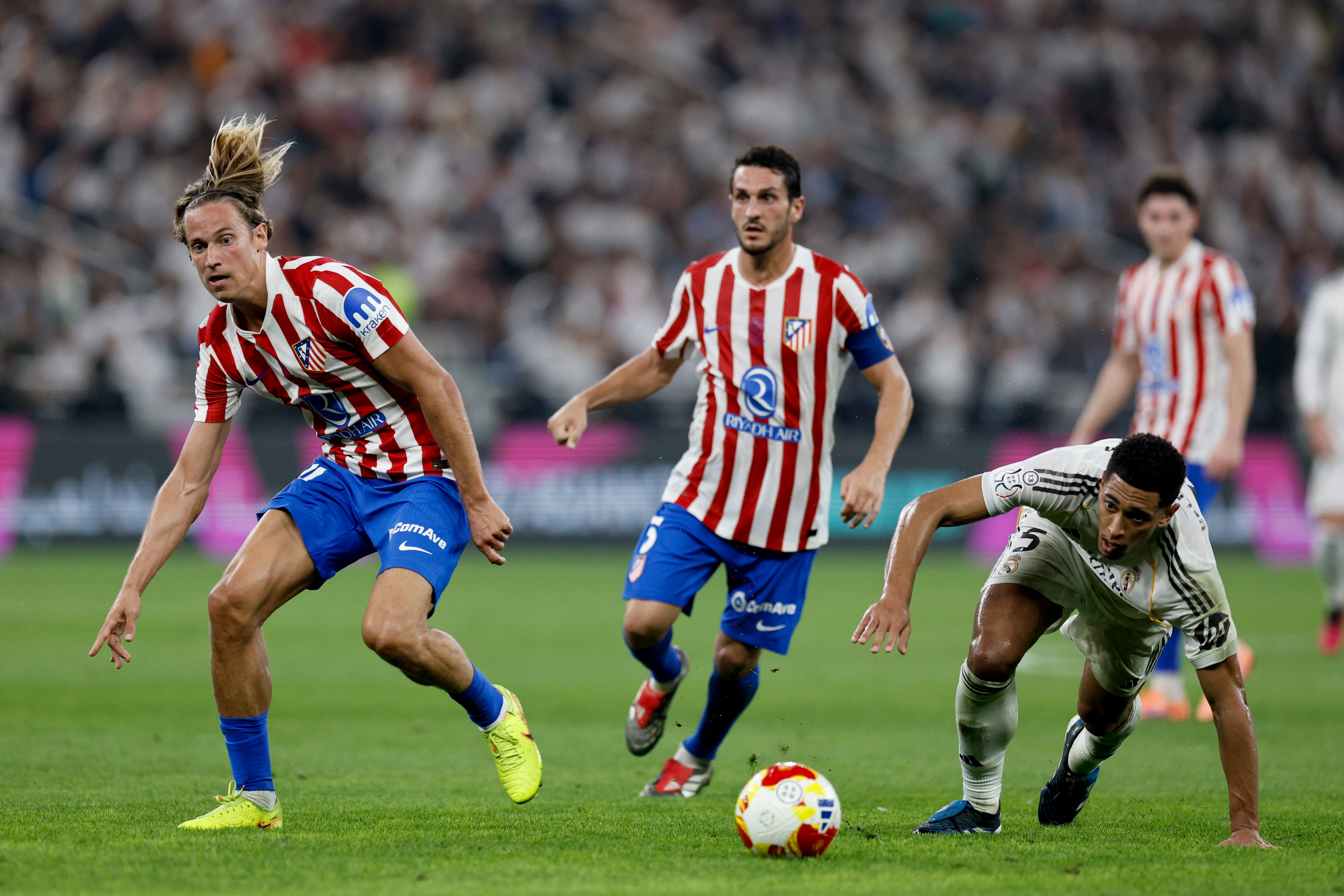 Jude Bellingham disputa un balón con Marcos Llorente durante la semifinal de la Supercopa de España entre el Atlético de Madrid y el Real Madrid. EFE/Kai Forsterling