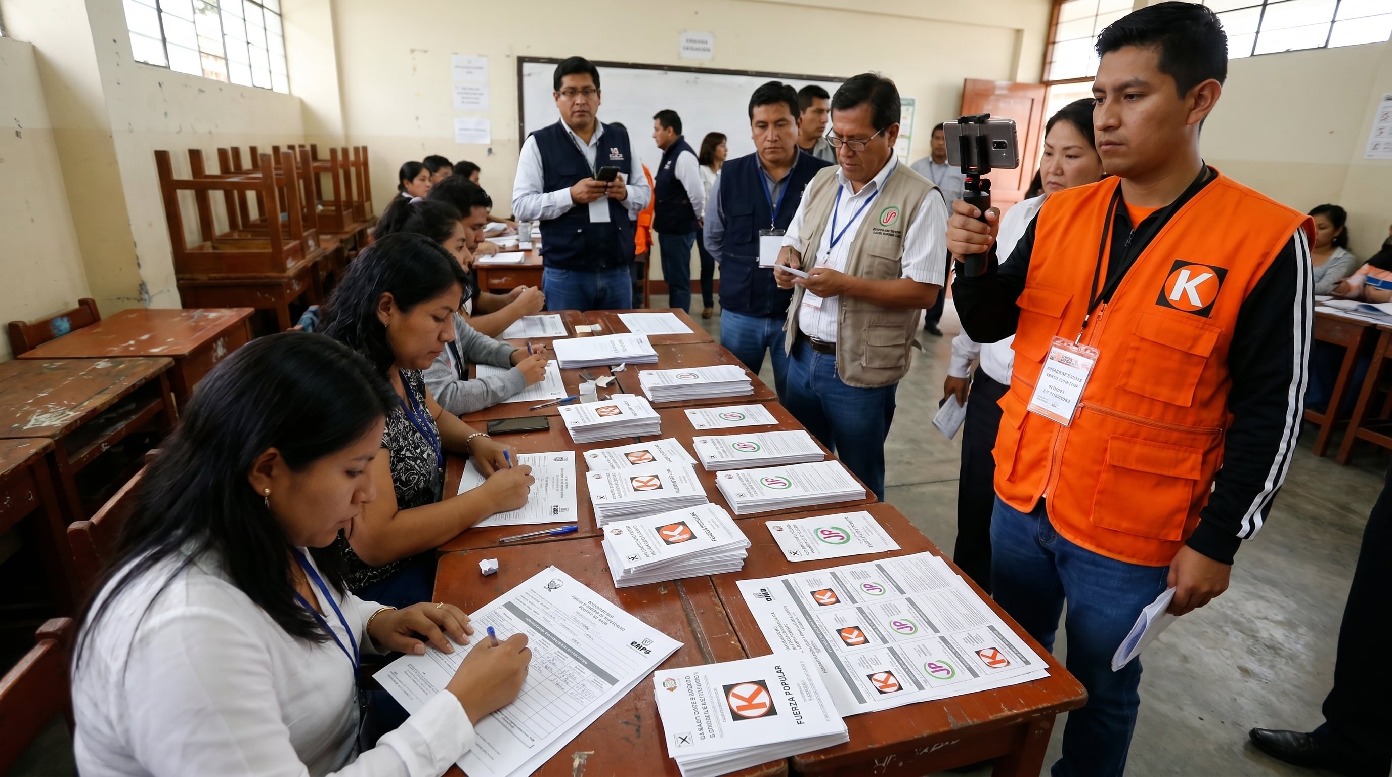 Miembros de mesa realizan el conteo de votos de las cédulas electorales, mientras un personero de Fuerza Popular graba el proceso con un smartphone, asegurando la transparencia electoral. (Imagen Ilustrativa Infobae)