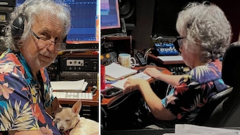 Un hombre mayor de cabello blanco, gafas y camisa estampada con motivos tropicales, junto a un perro chihuahua, opera equipos en un estudio de grabación
