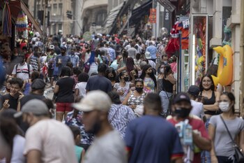 Shoppers wearing protective masks walk