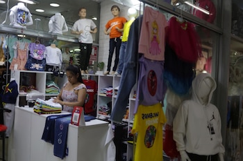 Clothing store owner Estefany Aguirre folds clothes at her store in the Gamarra commercial area in Lima, Peru January 30, 2023. REUTERS/Pilar Olivares