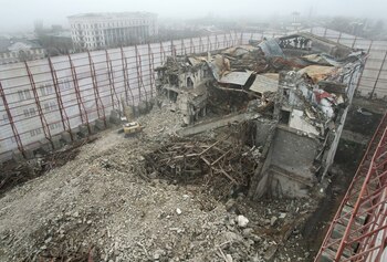 Una excavadora retira las ruinas