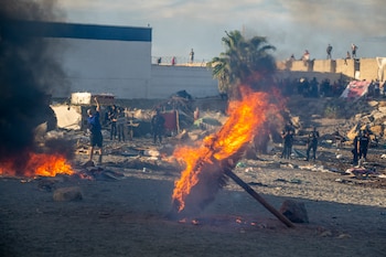Mobiliario urbano y enseres arden durante una manifestación para protestar por la situación provocada por la llegada masiva de migrantes, a 27 de agosto de 2026, en Ceuta (España). (Marcos Moreno/Europa Press)