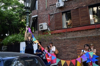 Seguidoras colocan una guirnalda de