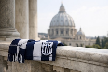 Bufanda de Alianza Lima, azul y blanco con escudo, sobre baranda de mármol en galería del Vaticano. Cúpula de San Pedro desenfocada al fondo.