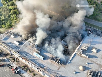 Distribuida por la administración militar ucraniana, bomberos trabajan en la extinción de un incencio en un centro comercial tras un ataque ruso con drones en Krivói Rog, Ucrania, el 21 de agosto de 2026. (Administración militar ucraniana vía AP)