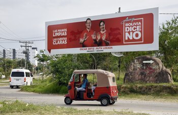 Un conductor de tuk-tuk transporta