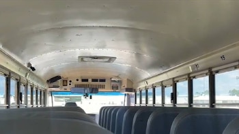 Vista interior de un vagón del M Train con filas de asientos vacíos y ventanas a lo largo de los lados, destacando el techo curvado y elementos superiores