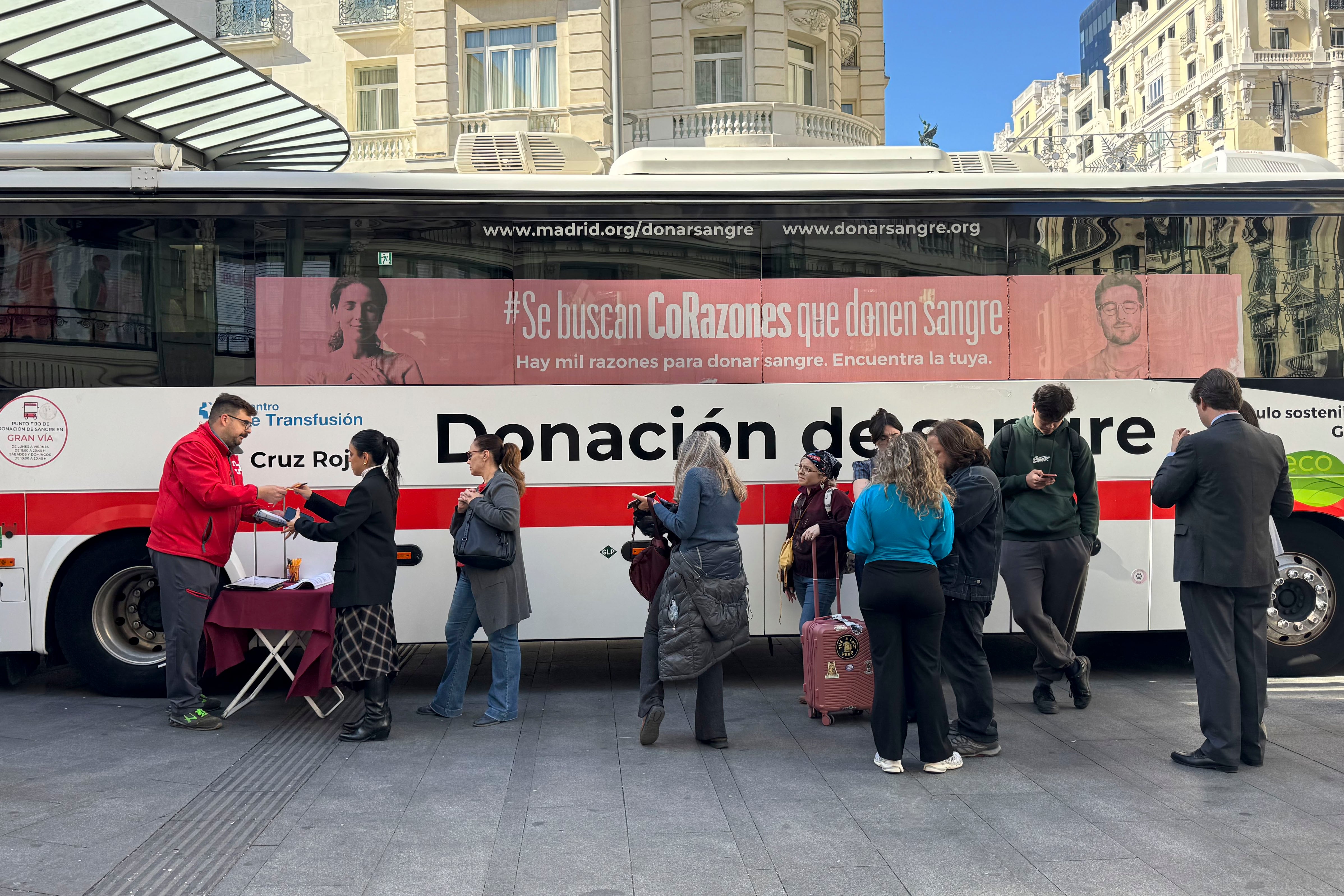 Varias personas donan sangre en un autobús de la Cruz Roja situado en Gran Vía tras conocerse la colisión de dos trenes de alta velocidad. (Nahia Peciña/EFE)