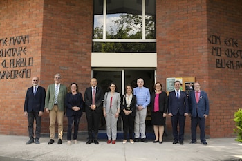 Catorce personas, hombres y mujeres, posan frente a un cartel de "25 Aniversario" en un vestíbulo moderno. El logo de SICA es visible en el balcón superior