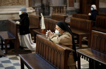 Nuns wearing protective masks and gloves pray during Easter Sunday Mass at Duomo di Napoli Cathedral, as Italy remains on lockdown to try and contain the spread of coronavirus disease (COVID-19), Naples, Italy, April 12, 2020. REUTERS/Ciro De Luca