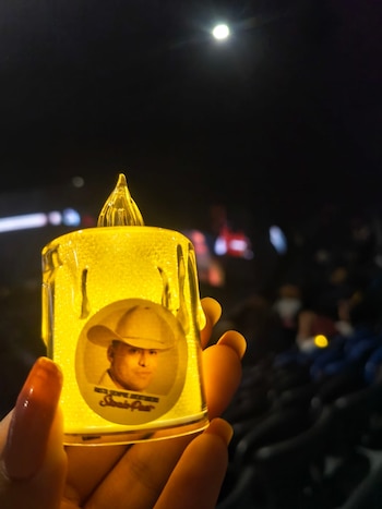 Los asistentes al evento recibieron una vela con el rostro del artista que encendieron durante la noche para recordarlo - crédito Infobae Colombia