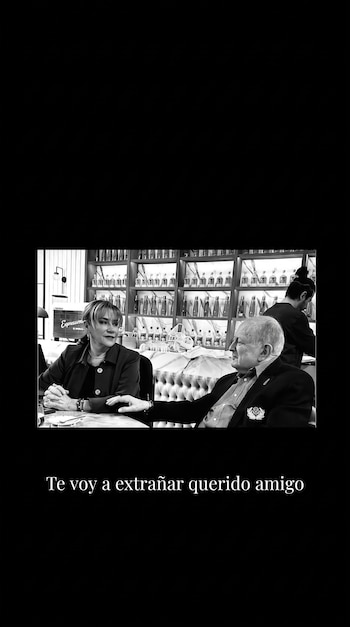 Fotografía en blanco y negro de una mujer y un hombre sentados a una mesa, con la frase Te voy a extrañar querido amigo en la parte inferior.