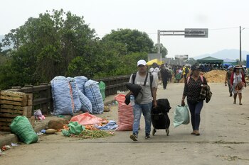 Personas tienen que atravesar a pie los cortes de ruta y tomar vehículos del otro lado del piquete para poder tansportarse. Foto de la localidad Ichilo, en Santa Cruz, el 22 de octubre de 2024. (Photo by RODRIGO URZAGASTI / AFP)