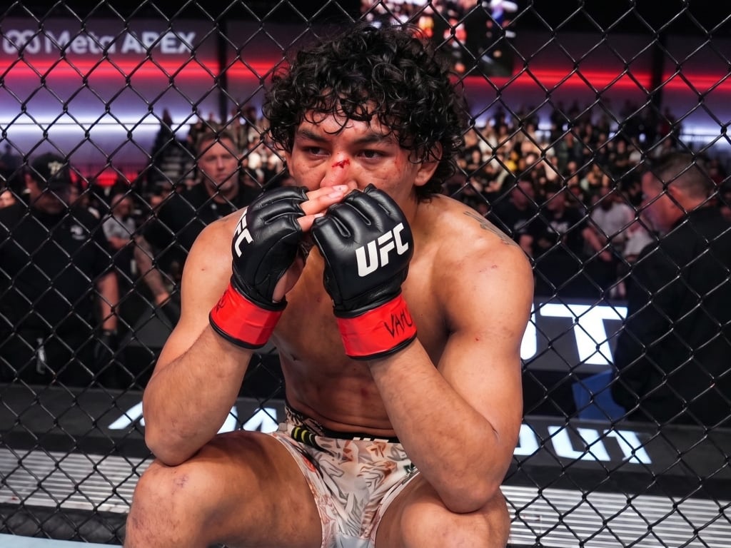 El peleador Raúl Rosas Jr. permanece sentado dentro del octágono tras vencer por nocaut a Raoni Barcelos en un evento de la UFC. (Captura de pantalla: X)