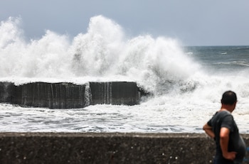 Un hombre observa el fuerte oleaje en la costa de Yilan mientras el tifón Bavi se aproxima al noreste de Taiwán (I-Hwa Cheng / AFP)