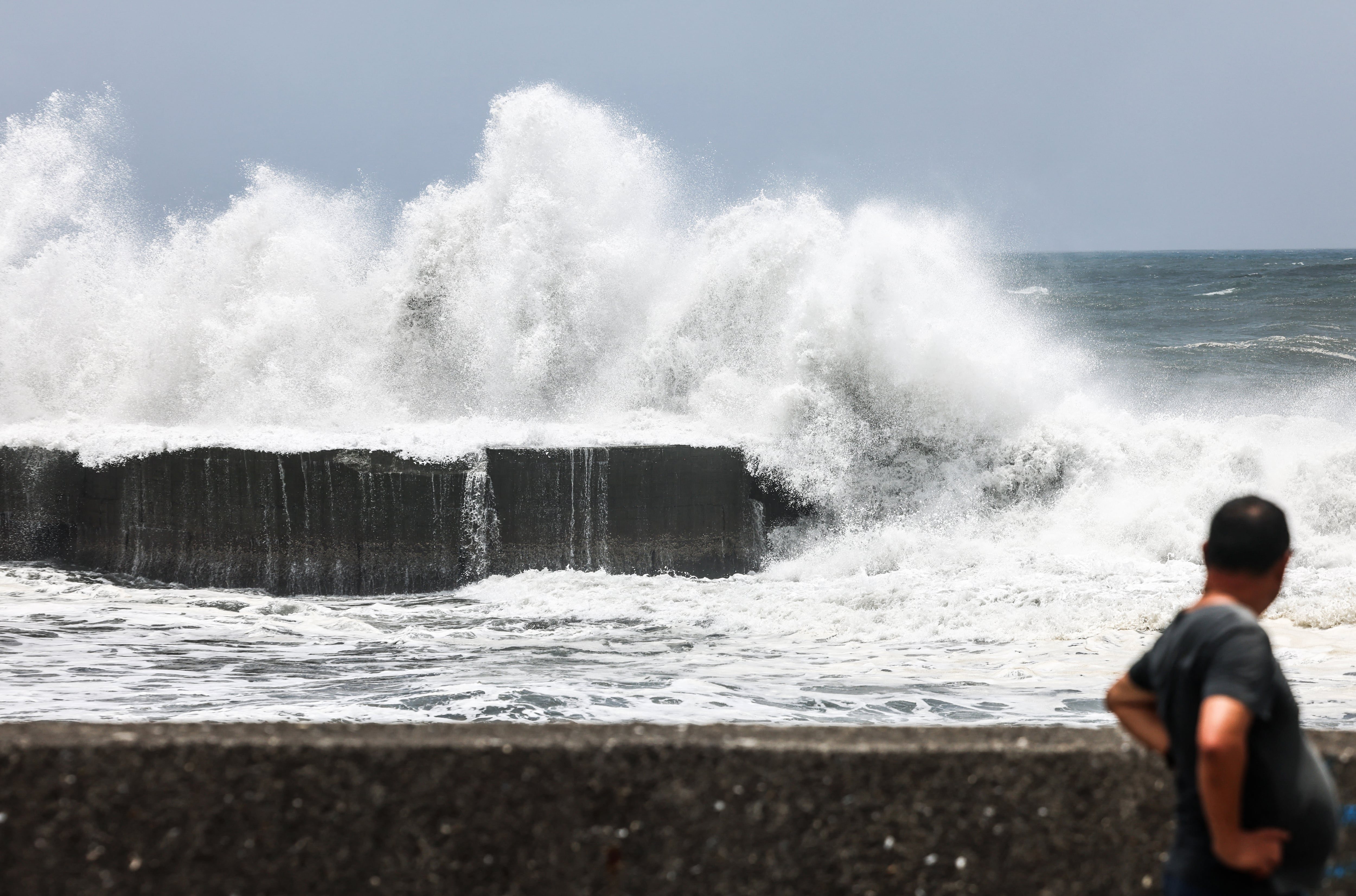 Un hombre observa el fuerte oleaje en la costa de Yilan mientras el tifón Bavi se aproxima al noreste de Taiwán (I-Hwa Cheng / AFP)