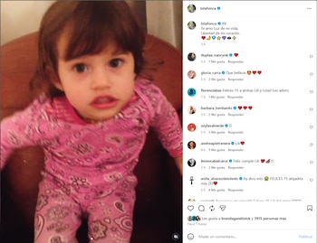 Primer plano de una niña pequeña con cabello oscuro y un pijama rosa estampado, mirando directamente a la cámara con la boca ligeramente abierta