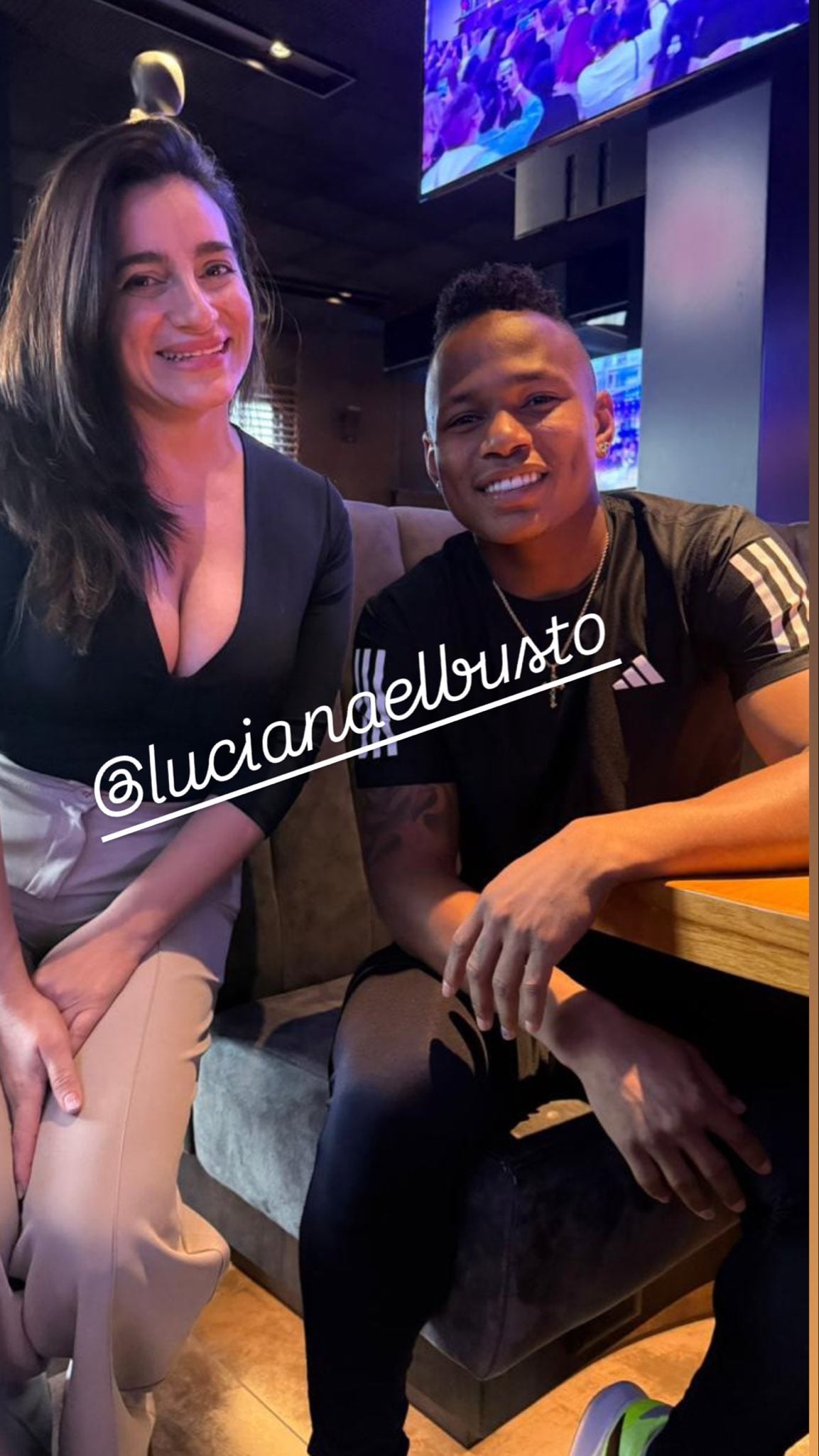 Gisela Gordillo permanece sentada en un sillón junto a su pareja en el interior de un local gastronómico.
