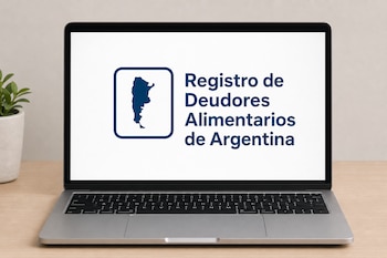 Computadora portátil sobre una mesa de madera con el logotipo y el texto del Registro de Deudores Alimentarios de Argentina en la pantalla.