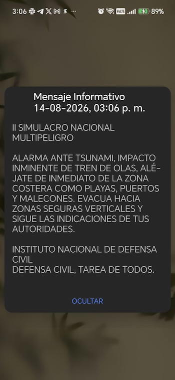 Pantalla de celular con mensaje informativo de simulacro nacional multipeligro de tsunami del Instituto Nacional de Defensa Civil y botón ocultar
