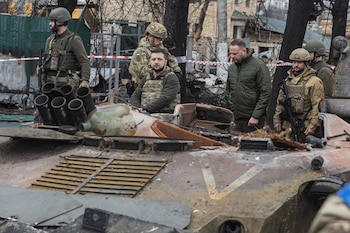 Zelensky pasa por delante de un vehículo militar ruso destruido mientras es rodeado por militares ucranianos en Bucha, a las afueras de Kiev (Reuters)