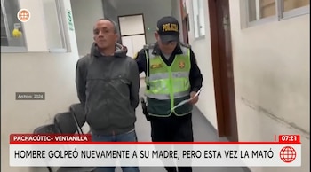 Un policía camina junto a un hombre detenido que lleva las manos esposadas en la espalda dentro de un pasillo